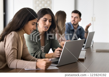 Two women colleagues review data on laptop 123924192