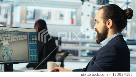 Engineer in photovoltaics factory using PC screen to diagnose malfunctioning systems. Solar panels manufacturing plant worker at computer desk maintaining system operational reliability, camera B 123924193