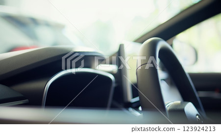 Close up of car interior with steering wheel and infotainment system screen. Panning shot of integrated multimedia vehicle computer inside automobile combining functions improving driving Close up of car interior with steering wheel and infotainment system screen. Panning shot of integrated multimedia vehicle computer inside automobile combining functions improving driving 123924213