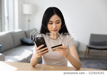 Young customer woman holding smartphone and credit card 123924241