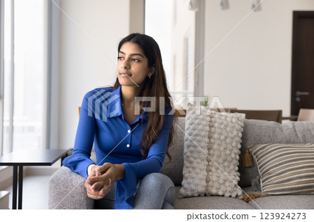 Young Indian woman gaze thoughtfully out of window Young Indian woman gaze thoughtfully out of window 123924273