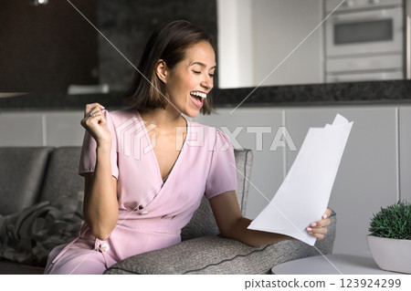 Woman reading document with expression filled with joy and excitement 123924299