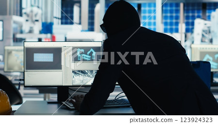 Masked worker in photovoltaics factory commits corporate espionage, stealing proprietary technology using USB stick. Man exploits insider access to copy trade secrets from solar panel plant, camera B 123924323
