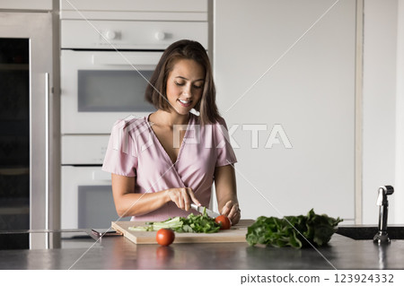 Beautiful woman chopping fresh vegetables for lunch or dinner 123924332
