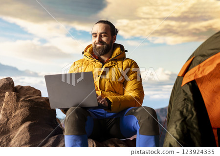 Modern online entrepreneur with technology reliance on a mountain top, always connected workaholic hiker admires the scenic landscape. Remote access with high connectivity and speed. Modern online entrepreneur with technology reliance on a mountain top, always connected workaholic hiker admires the scenic landscape. Remote access with high connectivity and speed. 123924335