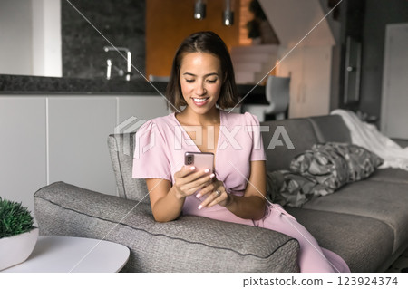 Beautiful European woman using smartphone at home leisure 123924374