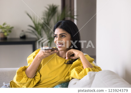 Indian woman holds smartphone, lead remote talk through speakerphone Indian woman holds smartphone, lead remote talk through speakerphone 123924379