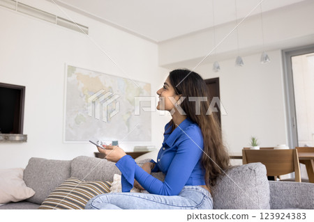 Woman switching on air conditioner, cooling or warming living room Woman switching on air conditioner, cooling or warming living room 123924383
