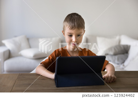 Little boy using modern digital tablet device at home Little boy using modern digital tablet device at home 123924402
