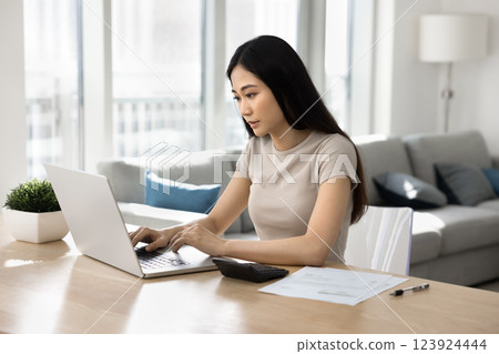 Focused Asian woman busy in personal expenses management 123924444