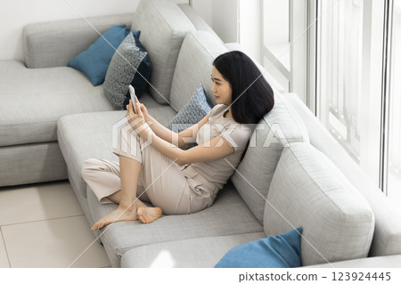 Asian woman spend time with smartphone in spacious living room 123924445