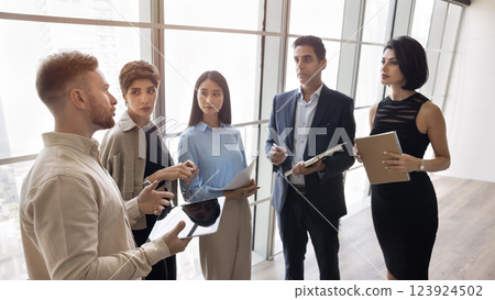 Young businessman talk to diverse polyethnic colleagues group at office 123924502