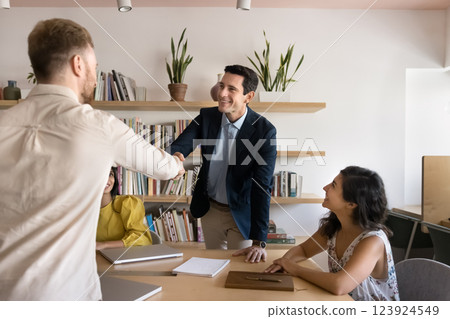 Young man academic team leader handshake with student in library Young man academic team leader handshake with student in library 123924549