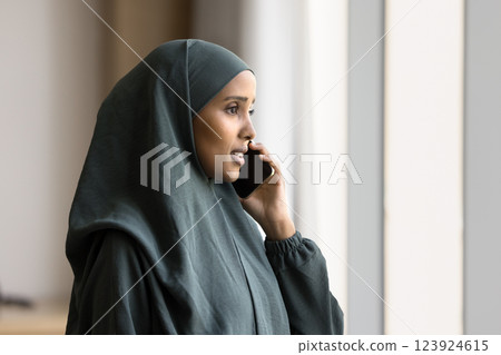 Young Arabian businesswoman engaged in business phone conversation Young Arabian businesswoman engaged in business phone conversation 123924615