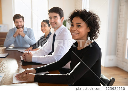 Teammates listening attentively to speaker, seated at conference table Teammates listening attentively to speaker, seated at conference table 123924630