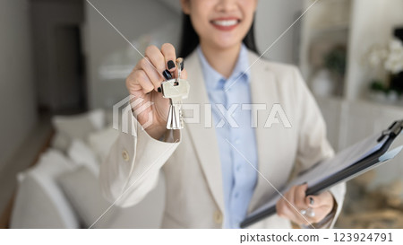 Female real estate agent showing key close up Female real estate agent showing key close up 123924791