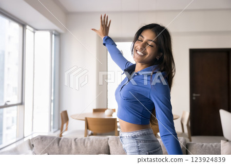Indian woman moving to popular music with her eyes closed Indian woman moving to popular music with her eyes closed 123924839