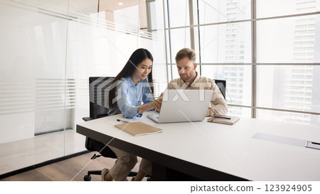 Young Asian woman mentor help European male intern by notebook 123924905