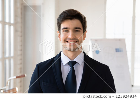 Businessman dressed in jacket and necktie posing at workplace 123924934