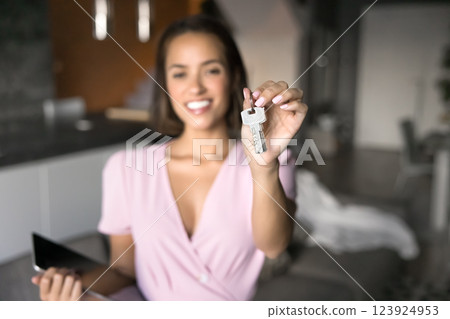 Realtor holds key toward camera and welcoming new homeowner Realtor holds key toward camera and welcoming new homeowner 123924953