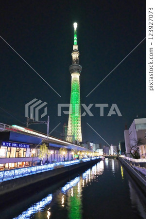 看著天空樹線列車沿著水路駛過,欣賞綠天樹的夜景 看著天空樹線列車沿著水路駛過,欣賞綠天樹的夜景 123927073