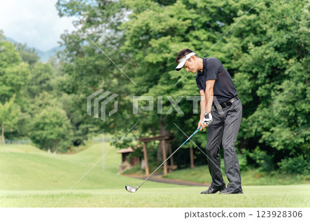 A golfer's man playing golf on a golf course (tee shot/golf competition) A golfer's man playing golf on a golf course (tee shot/golf competition) 123928306