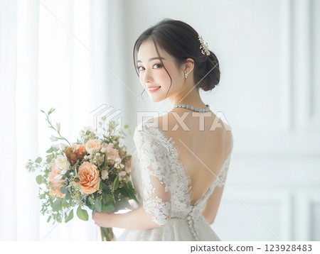 新娘穿著漂亮的露背婚紗，手裡拿著花束 123928483