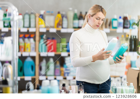Pregnant customer choosing shower gel in personal care store Pregnant customer choosing shower gel in personal care store 123928606