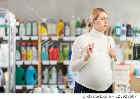 Interested pregnant woman choosing home care products in store Interested pregnant woman choosing home care products in store 123928607