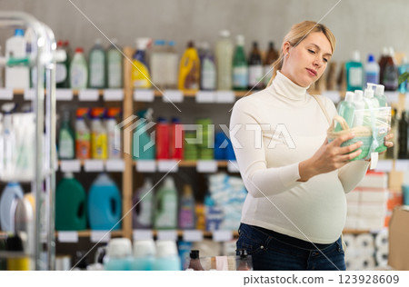 Pregnant woman choosing gift set with self-care products in store 123928609