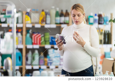 Pregnant woman choosing handcrafted scented candles in store 123928610