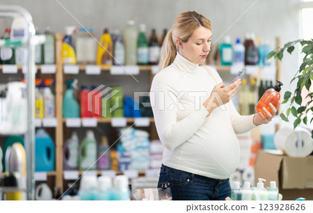 Pregnant woman scanning barcode on liquid soap in store 123928626