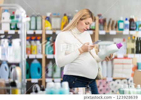 Pregnant shopper scanning fabric softener barcode for mobile payment Pregnant shopper scanning fabric softener barcode for mobile payment 123928639