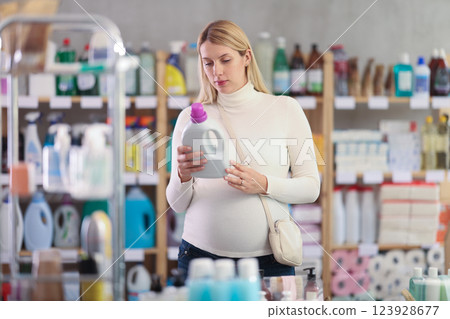 Pregnant woman choosing eco-friendly detergent in supermarket 123928677
