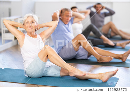 Elderly woman doing pilates in group Elderly woman doing pilates in group 123928773