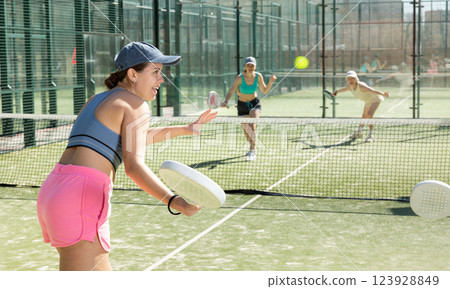 Young woman playing Padel Tennis in pairs in tennis court 123928849