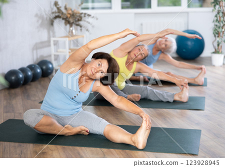 Mature lady performs pose Parivritta janu shirshasana Mature lady performs pose Parivritta janu shirshasana 123928945