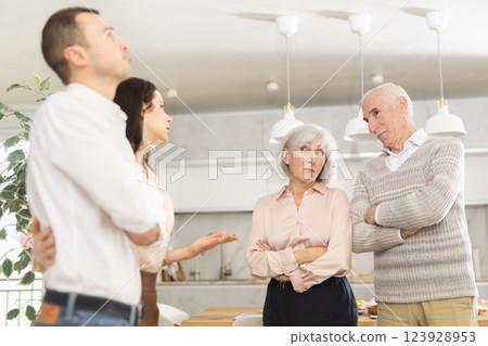 Adult daughter introducing boyfriend to disapproving elderly parents at home Adult daughter introducing boyfriend to disapproving elderly parents at home 123928953