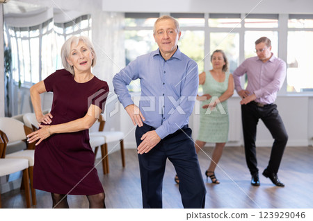 Senior man and elderly woman are dancing contemporary twist in couple Senior man and elderly woman are dancing contemporary twist in couple 123929046