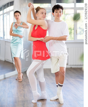 Girl and boy dancing slow ballroom dance in choreography studio Girl and boy dancing slow ballroom dance in choreography studio 123929139