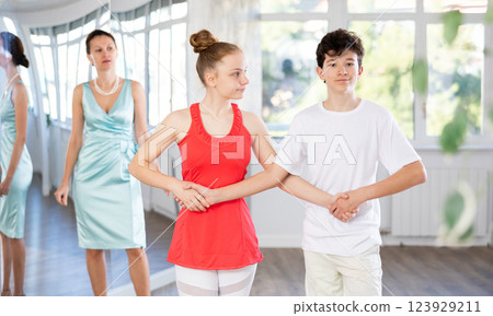 Dance teacher teaching young teenage couple ancient dances Dance teacher teaching young teenage couple ancient dances 123929211