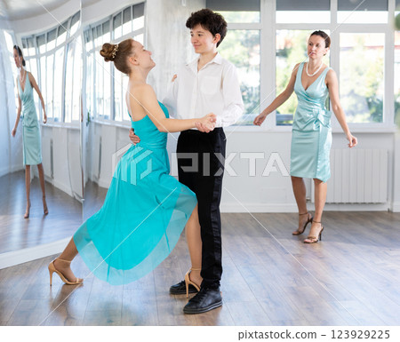 Dance teacher teaches a girl and a boy couples ballroom dancing Dance teacher teaches a girl and a boy couples ballroom dancing 123929225