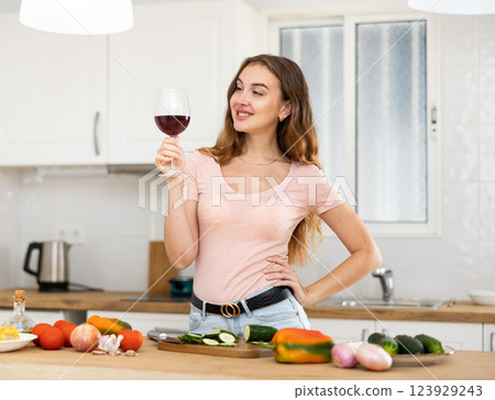 Portrait young woman with a glass of wine in the kitchen Portrait young woman with a glass of wine in the kitchen 123929243