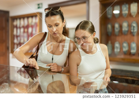 Woman and teenage girl looking at exhibit in museum display 123929351