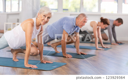 Elderly woman doing pilates in group 123929364