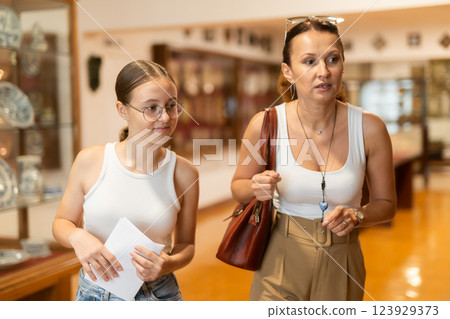 Woman and teenage girl looking at exhibition of tableware 123929373
