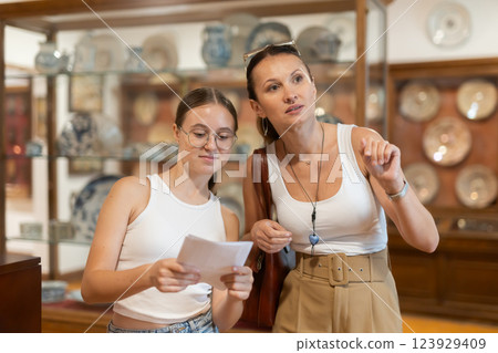Woman and teenage girl looking at exhibition of tableware Woman and teenage girl looking at exhibition of tableware 123929409