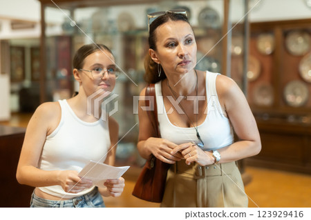 Woman and teenage girl looking at exhibition of tableware Woman and teenage girl looking at exhibition of tableware 123929416