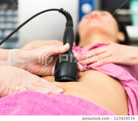 Female abdomen during professional ultrasonic fat cavitation procedure 123929539