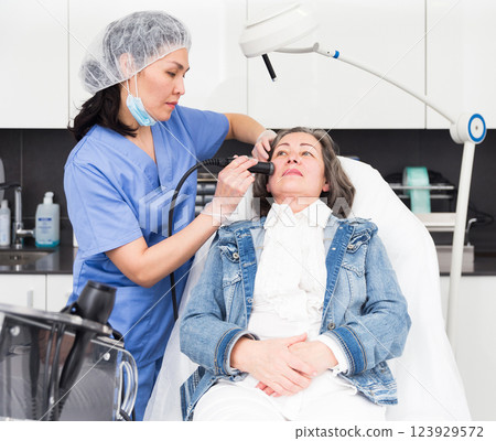 Elderly female client receiving hardware mesotherapy at cosmetology clinic 123929572